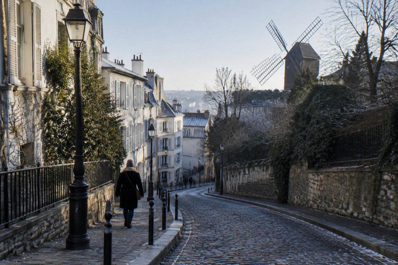 A quiet sloping Paris street lined with lampposts and old apartment buildings