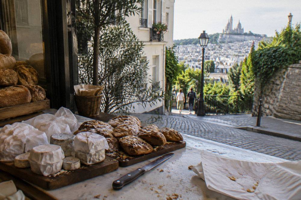Cheese and pastry counter display in a small Montmartre food shop