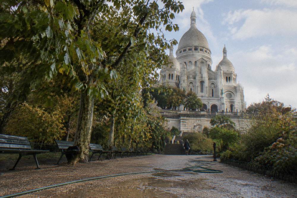 Sacre-Coeur white domes seen from a garden terrace above Paris rooftops