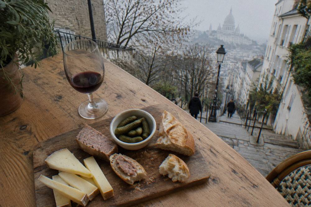 A spread of cheese, charcuterie and bread on a wooden counter