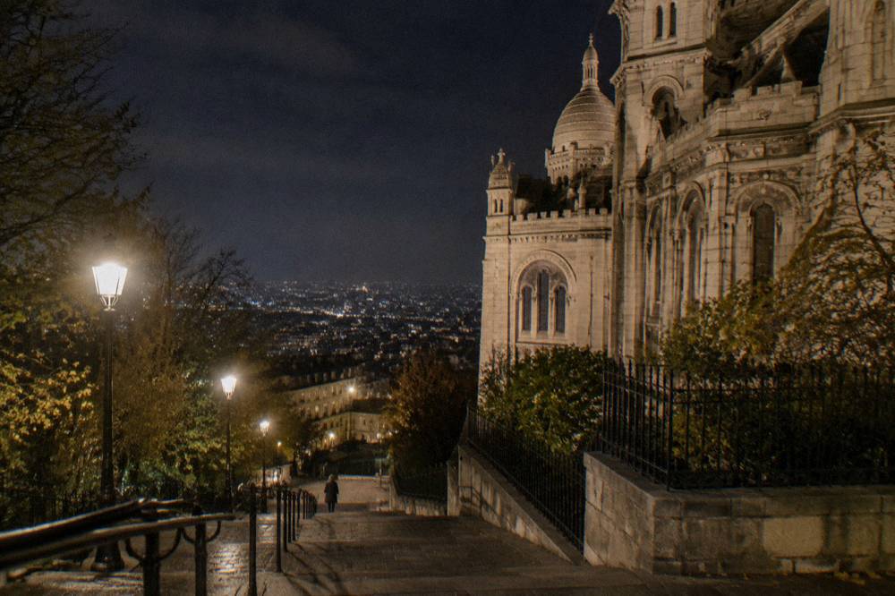 Illuminated facade and street lamps on a Montmartre boulevard at night