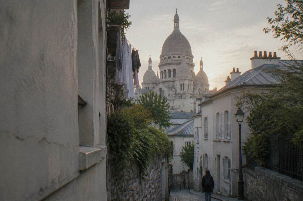 White stone dome of Sacre-Coeur basilica seen from a Montmartre street