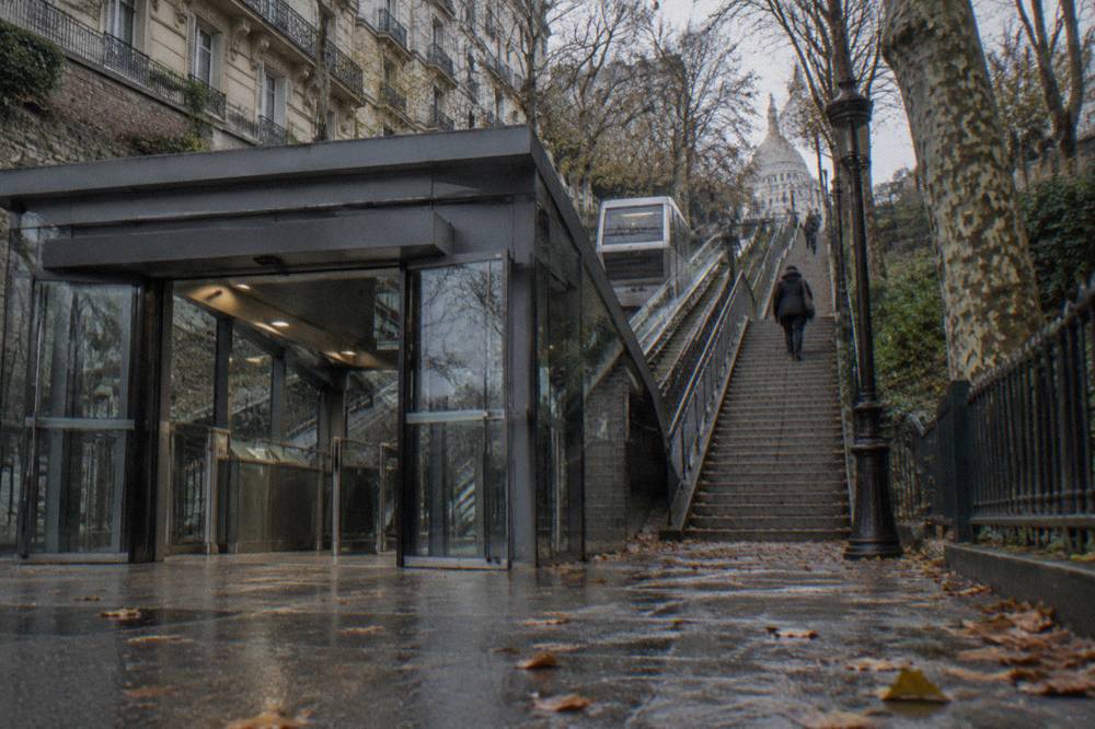 The lower funicular station at the foot of the Montmartre hill with the stairway rising alongside it