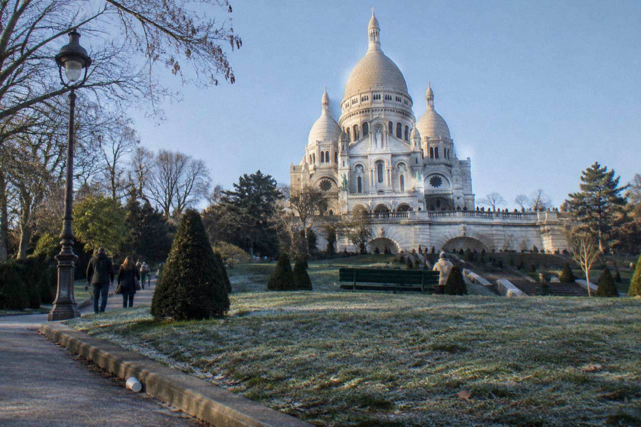The white domed basilica of Sacre-Coeur seen from the lawns below on a bright afternoon