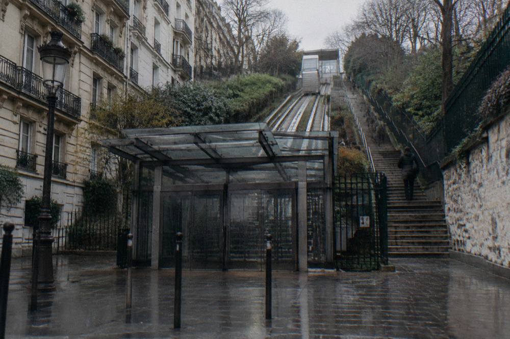 The lower funicular station entrance at the foot of the Montmartre hill with the ascending stairs behind it
