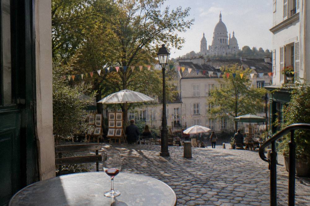 A festival crowd on a Paris hilltop square with bunting strung between buildings