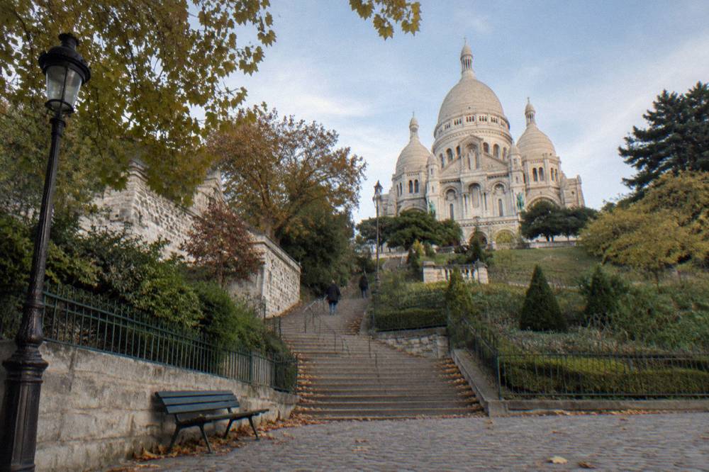 The white domed basilica on the hill seen from the gardens and stairs below at street level